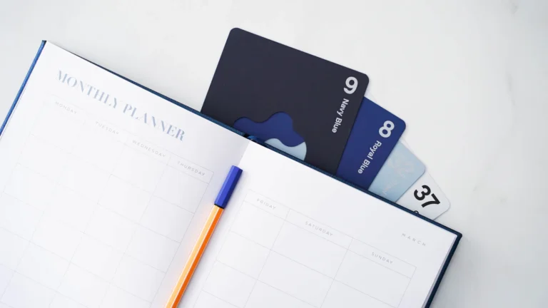 Notebook, pen and credit cards arranged on a desk for payment-date planning