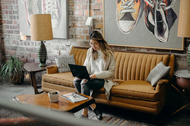 Woman using a laptop at home while reviewing personal finances