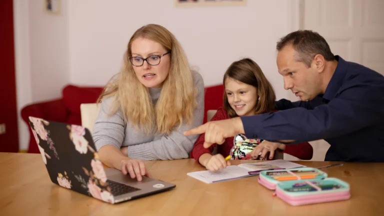 Two adults and a child looking at a laptop together