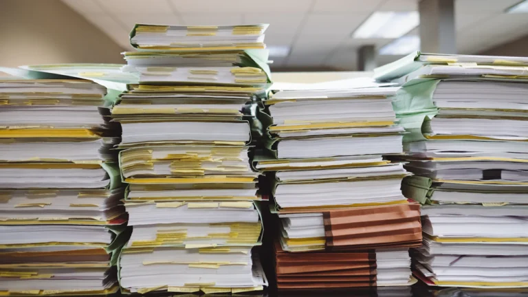 Paper documents sorted into folders and stacks